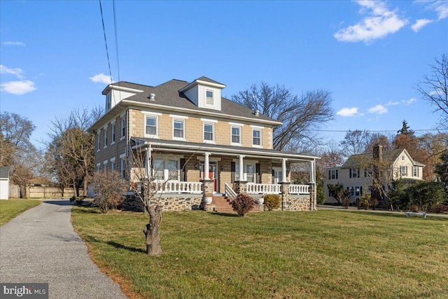 colonial-style house featuring a porch and a front yard