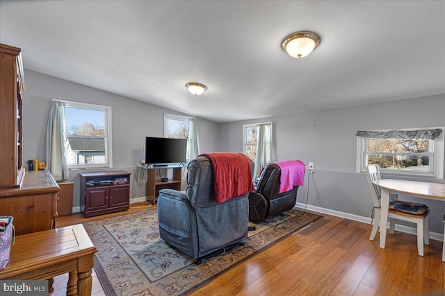 living room with light hardwood / wood-style floors and vaulted ceiling