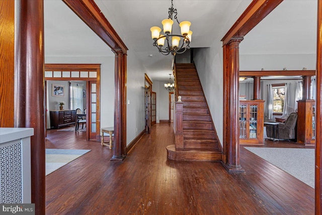 stairs featuring a notable chandelier, decorative columns, wood-type flooring, and french doors