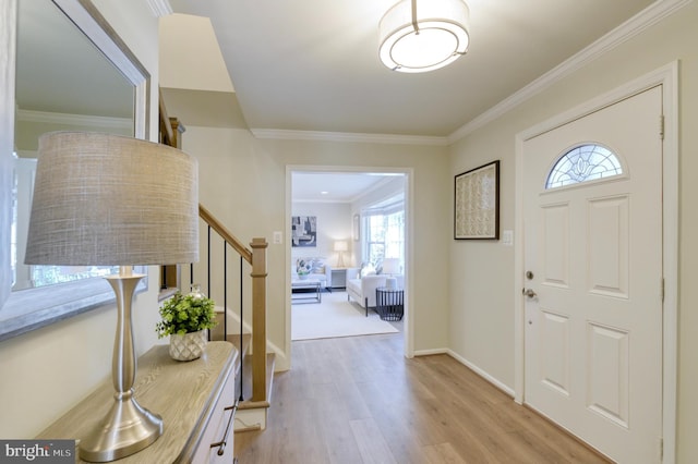 entrance foyer with light hardwood / wood-style flooring and crown molding