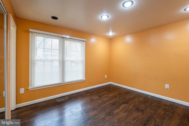 empty room with dark hardwood / wood-style flooring