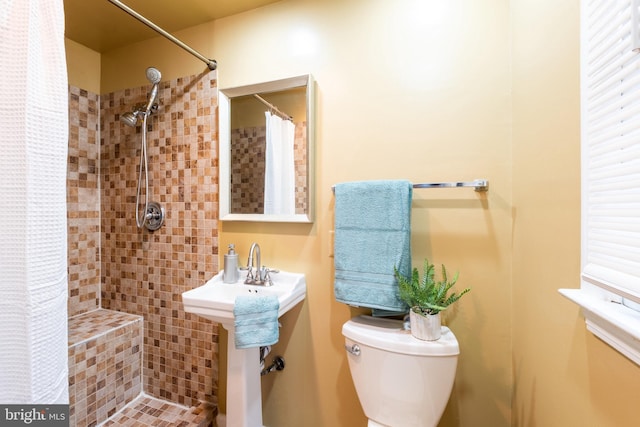 bathroom with a shower with shower curtain and toilet