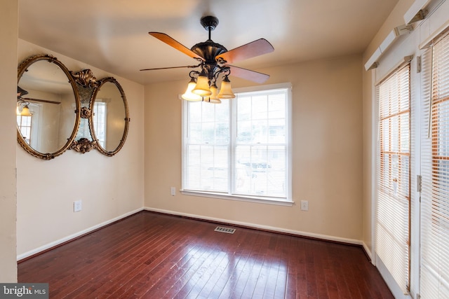 unfurnished dining area featuring ceiling fan and dark wood-type flooring