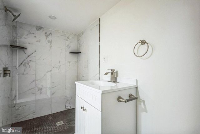 bathroom featuring a tile shower and vanity