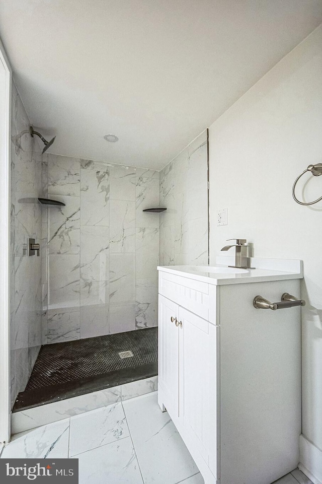 bathroom featuring a tile shower and vanity