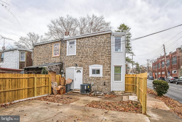 rear view of house with central AC unit and a patio area