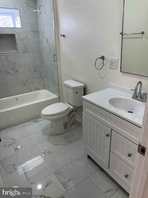 full bathroom with vanity, tiled shower / bath combo, and toilet