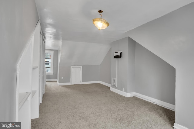 bonus room with light colored carpet and lofted ceiling