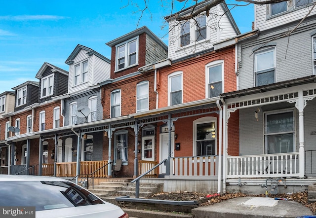 townhome / multi-family property featuring covered porch