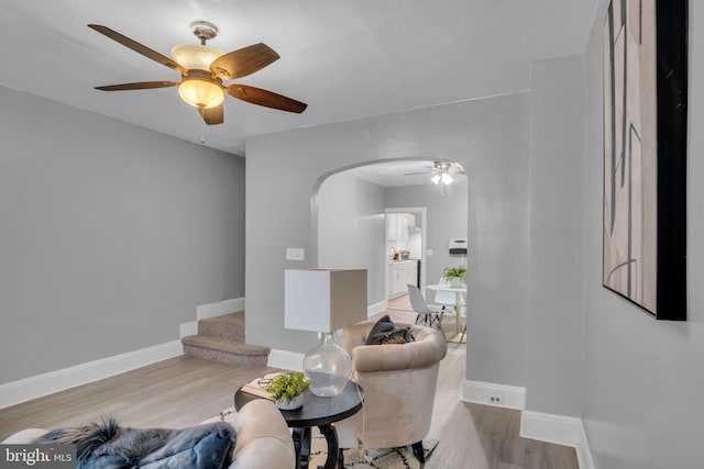 living room featuring ceiling fan and light hardwood / wood-style floors