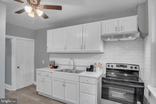 kitchen featuring white cabinets, light hardwood / wood-style floors, stainless steel electric range oven, and sink