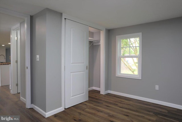 unfurnished bedroom featuring dark hardwood / wood-style flooring and a closet