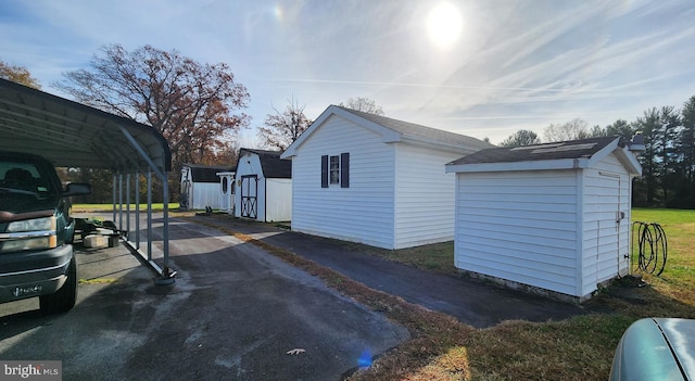 view of side of property featuring a carport and a storage shed