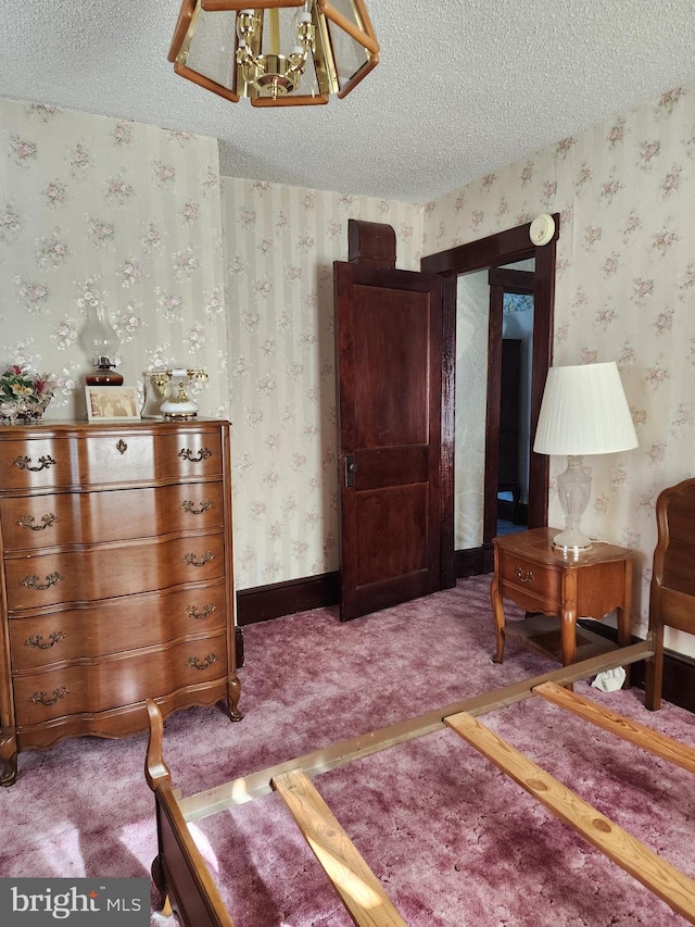 bedroom featuring carpet flooring, a textured ceiling, and an inviting chandelier