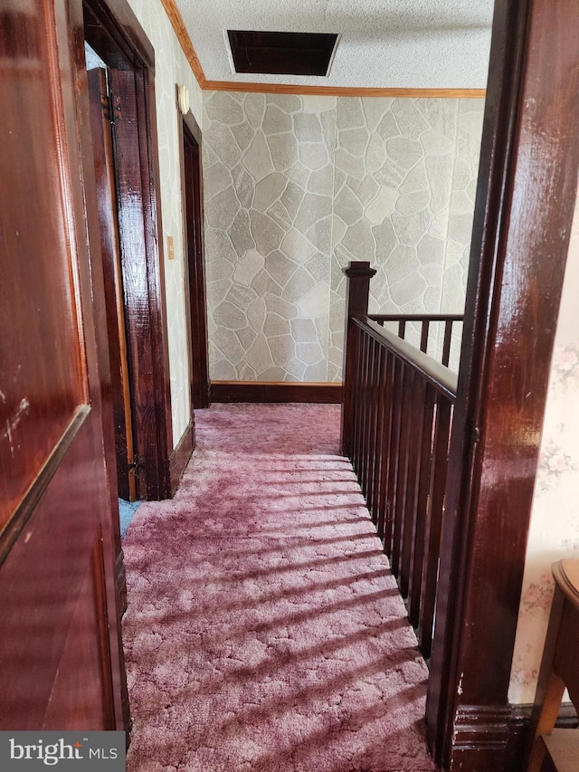 corridor with ornamental molding and carpet floors