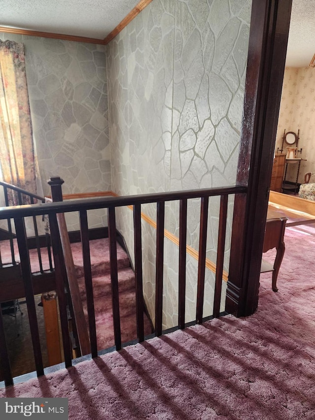 stairway featuring a textured ceiling, carpet floors, and crown molding