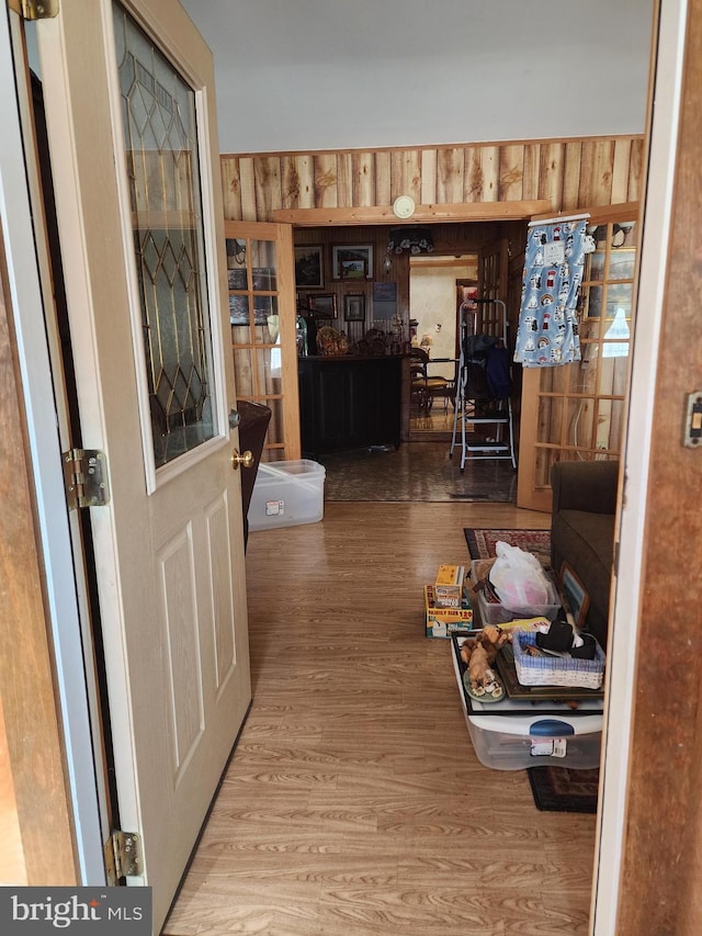 hallway featuring hardwood / wood-style flooring and wood walls