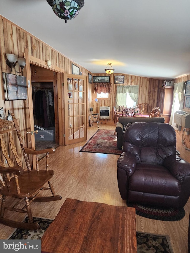 living room featuring hardwood / wood-style flooring, wooden walls, and heating unit