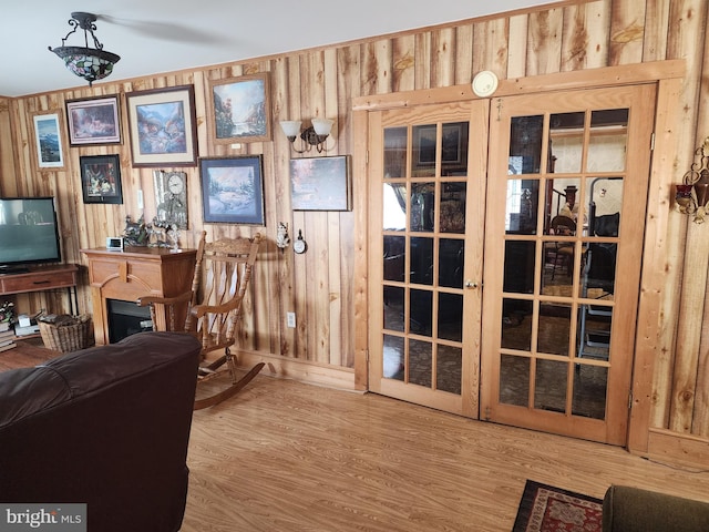 living area featuring hardwood / wood-style flooring and wooden walls