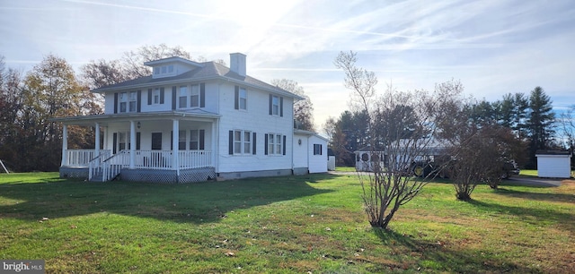 view of side of property with covered porch and a lawn