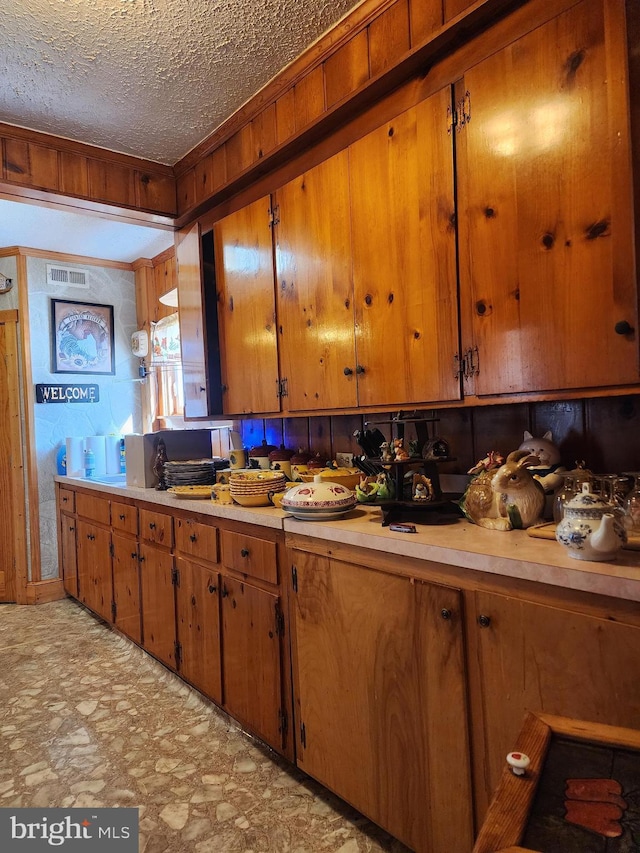 kitchen with wood walls and a textured ceiling