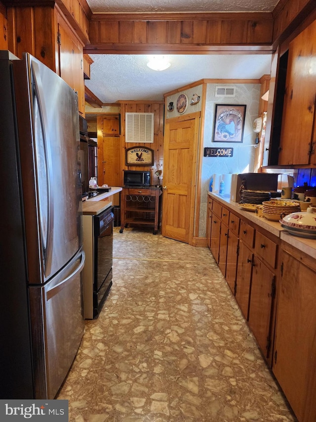 kitchen with crown molding, black appliances, and a textured ceiling