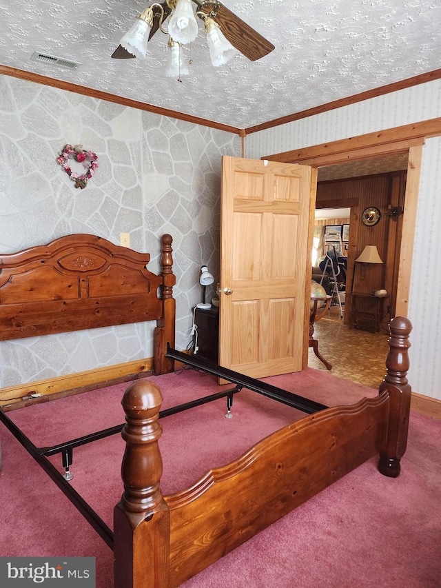 bedroom with a textured ceiling, carpet floors, ceiling fan, and crown molding