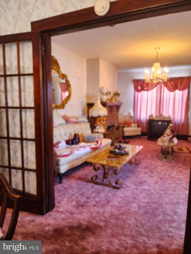 living room with carpet floors, a chandelier, and a brick fireplace