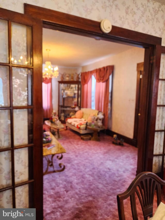 carpeted living room with a chandelier