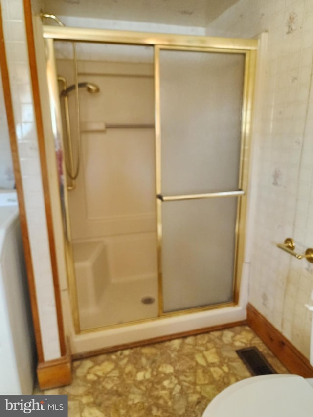 bathroom featuring a shower with door