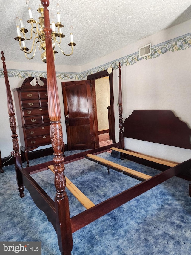 carpeted bedroom with a chandelier and a textured ceiling