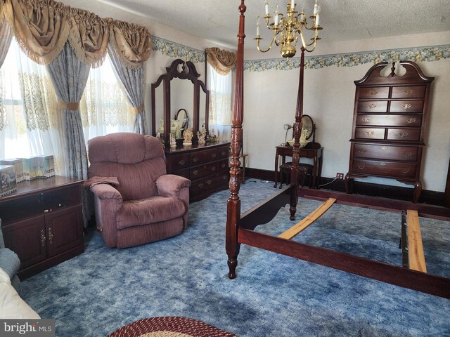 carpeted bedroom with a chandelier and a textured ceiling