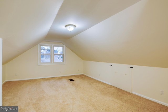 bonus room with light carpet and lofted ceiling