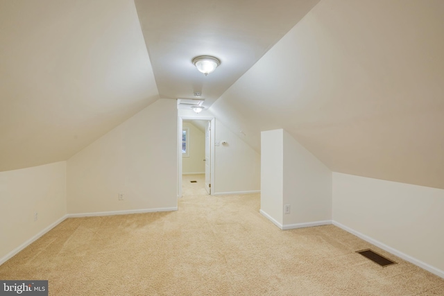 additional living space featuring light carpet and lofted ceiling