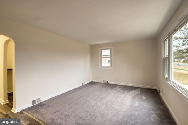 unfurnished room with dark carpet