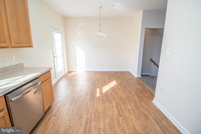 kitchen featuring hanging light fixtures, stainless steel dishwasher, and light hardwood / wood-style flooring