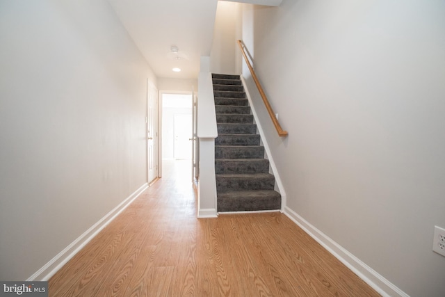 stairs featuring hardwood / wood-style floors