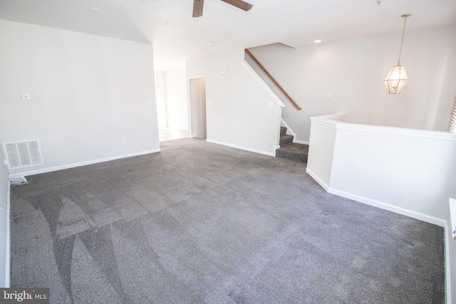 unfurnished living room featuring ceiling fan and dark colored carpet