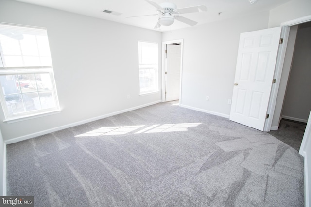 unfurnished bedroom with multiple windows, carpet floors, and ceiling fan