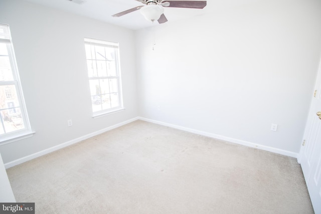 empty room featuring light carpet, ceiling fan, and a wealth of natural light