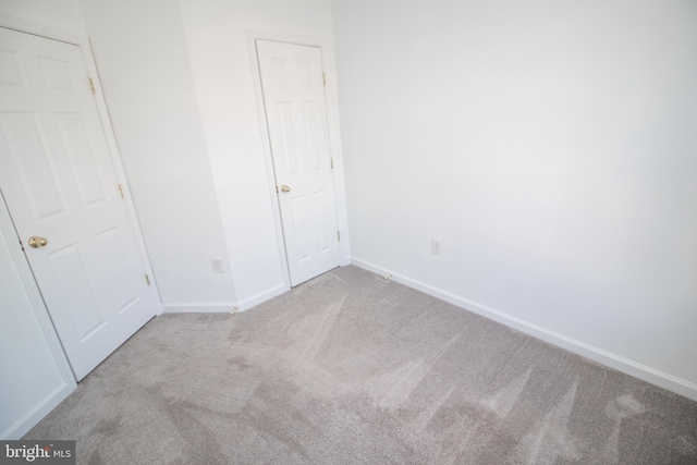 unfurnished bedroom featuring light carpet