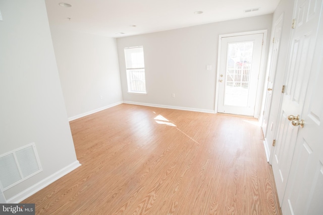 spare room featuring a wealth of natural light and light hardwood / wood-style flooring