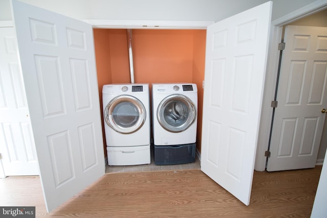 laundry room featuring independent washer and dryer and light wood-type flooring