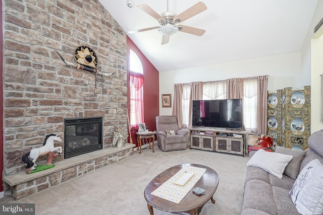 carpeted living room featuring ceiling fan, a stone fireplace, and high vaulted ceiling