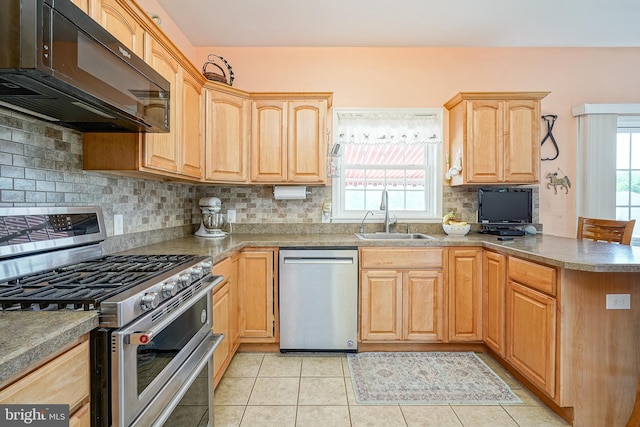 kitchen featuring a healthy amount of sunlight, sink, light tile patterned floors, and stainless steel appliances