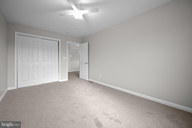 unfurnished bedroom with carpet flooring, ceiling fan, and a closet