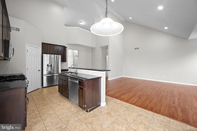 kitchen featuring sink, an island with sink, decorative light fixtures, light hardwood / wood-style floors, and stainless steel appliances