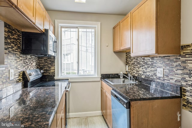 kitchen featuring decorative backsplash, dark stone countertops, sink, and appliances with stainless steel finishes