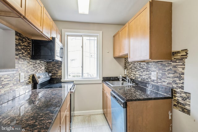 kitchen with stainless steel appliances, tasteful backsplash, dark stone countertops, and sink