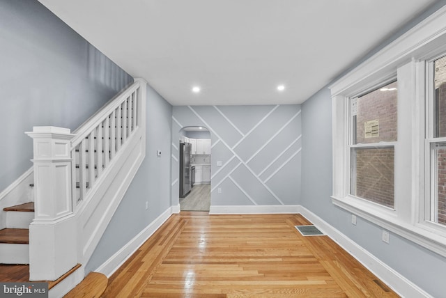 staircase featuring wood-type flooring and a wealth of natural light